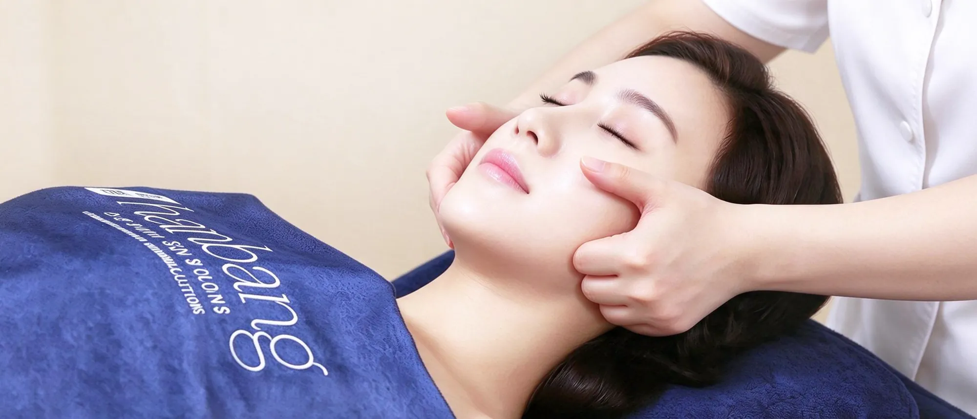A Hanbang therapist pressing along a client's cheekbones during Geunmak therapy